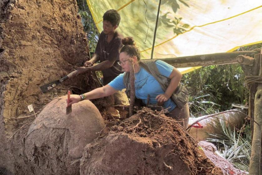 La arqueóloga Geórgea Holanda trabaja en una de las urnas funerarias recuperadas en la selva amazónica brasileña junto a otros arqueólogos