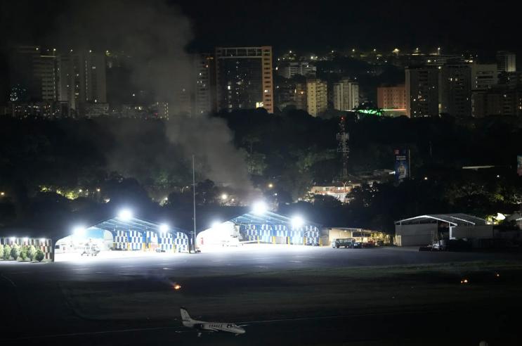Humo se eleva cerca del aeropuerto de La Carlota luego de escucharse explosiones y aviones volando bajo en Caracas, Venezuela, el sábado.