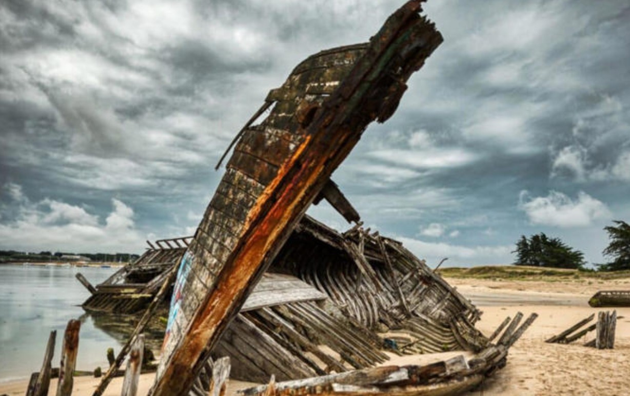 Restos de madera de un antiguo barco emergiendo de la arena en una playa del sur de Inglaterra por los arqueólogos