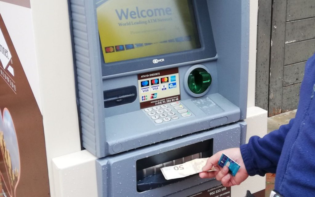 Persona sacando dinero en efectivo de un cajero automático en España donde la Agencia Tributaria vigila las retiradas a partir de 1.000 euros y puede investigar a partir de 3.000 euros